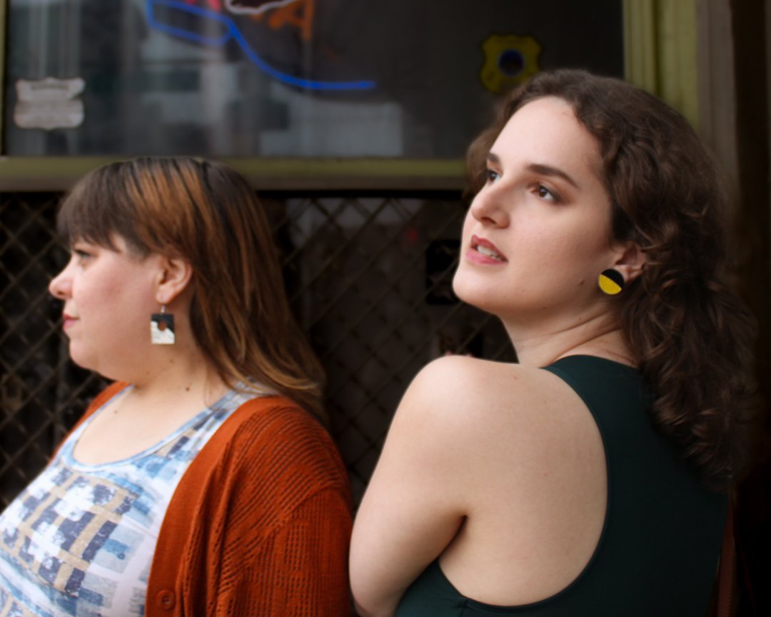 Two people wearing handcrafted reVinyled earrings