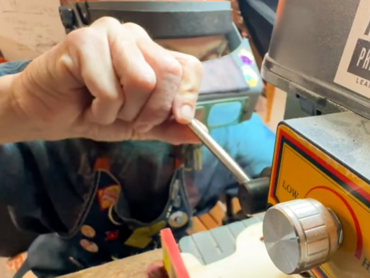 A reVinyled jewelry piece being drilled by hand